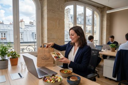Une professionnelle parisienne déballant un plateau repas commandé au bureau dans un open space moderne